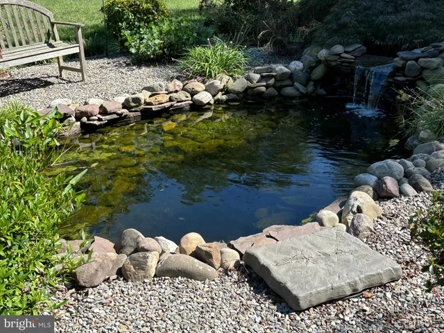 a view of a house with a yard and a pond