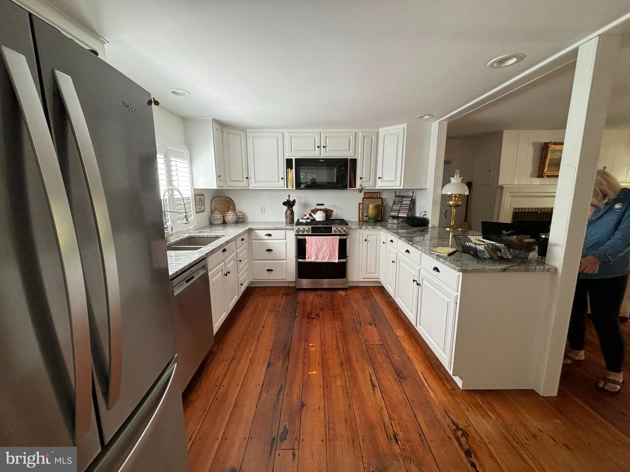 10230 John Carvill Road Chestertown, MD 21620 - Photo 7 of 41 a kitchen with stainless steel appliances a refrigerator a sink a stove top oven a wooden floor and cabinets