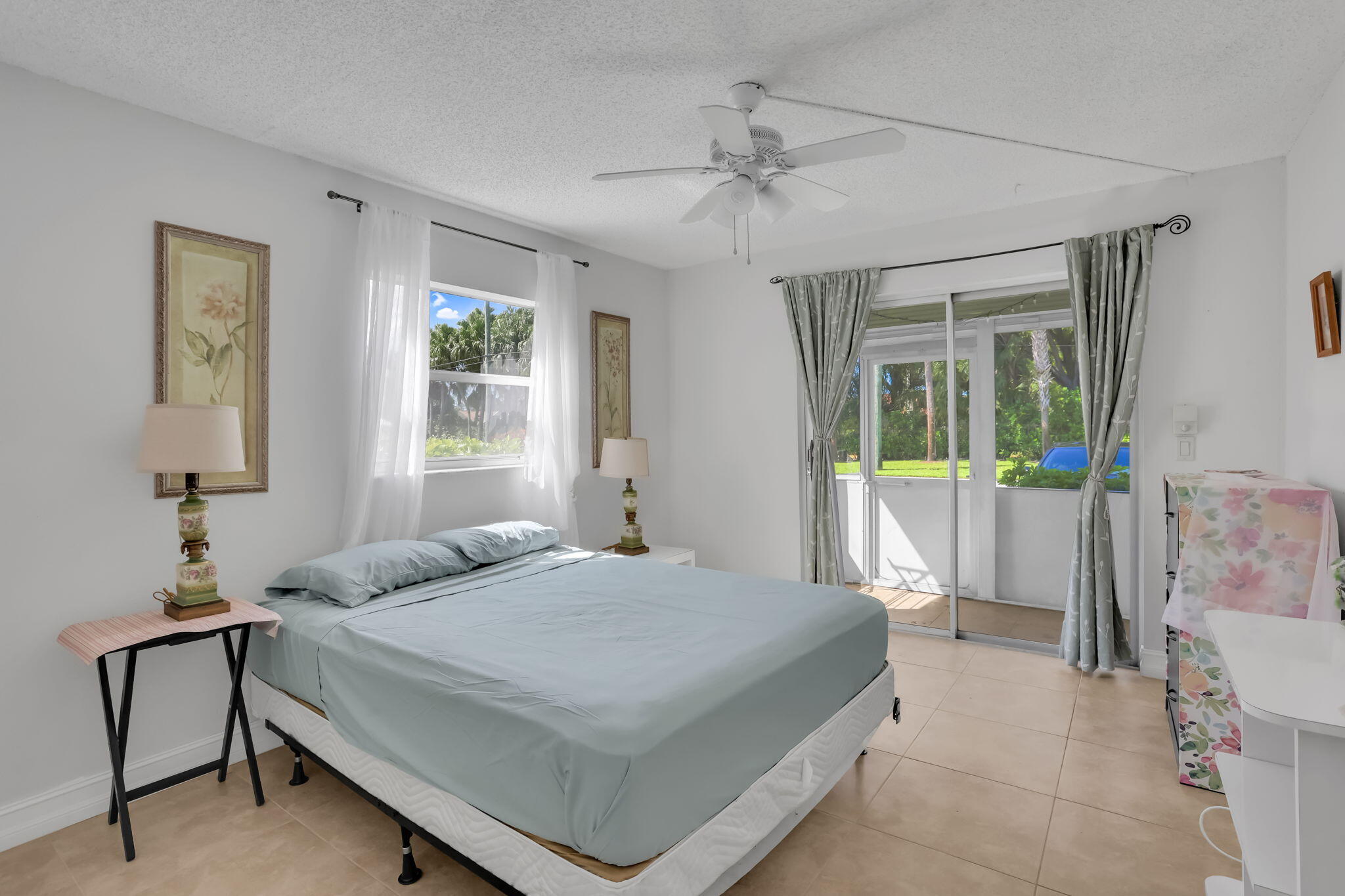 152 Tuscany Lane, Unit C Delray Beach, FL 33446 - Photo 19 of 40 a bedroom with a bed and a chandelier