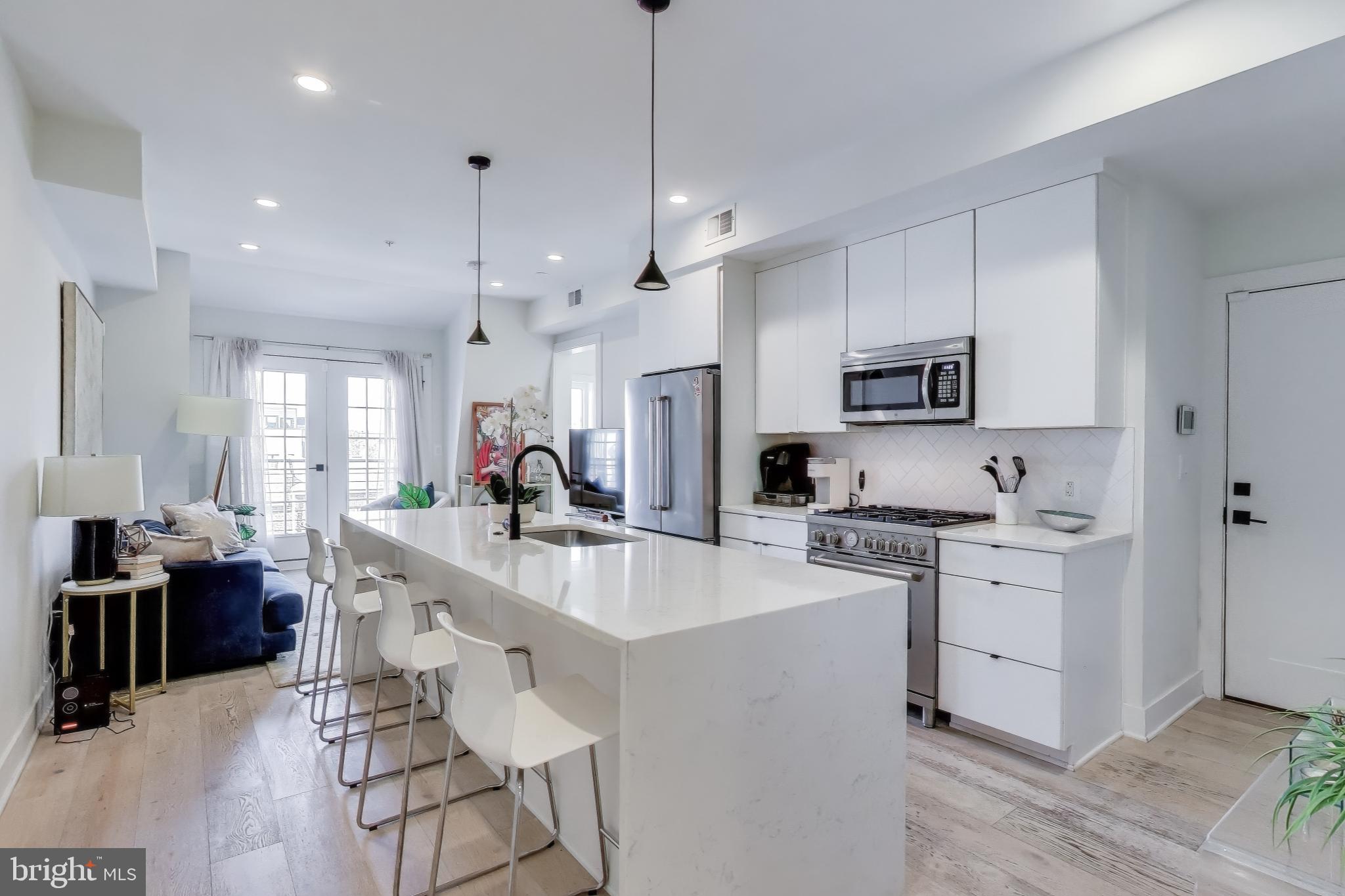 1011 18th Street Northeast, Unit 8 Washington, DC 20002 - Photo 2 of 25 a large kitchen with stainless steel appliances lots of counter space and windows