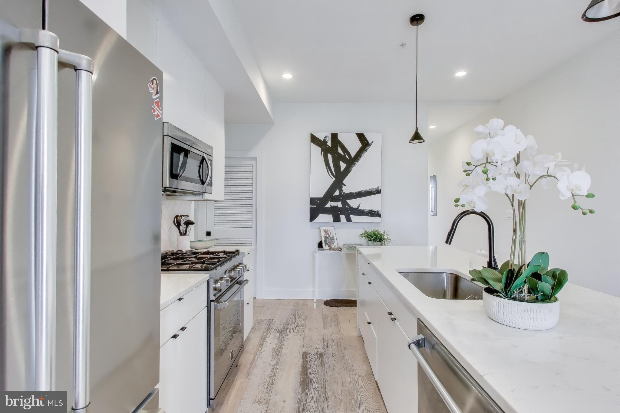 1011 18th Street Northeast, Unit 8 Washington, DC 20002 - Photo 3 of 25 a kitchen with stainless steel appliances a sink a counter space a stove and cabinets
