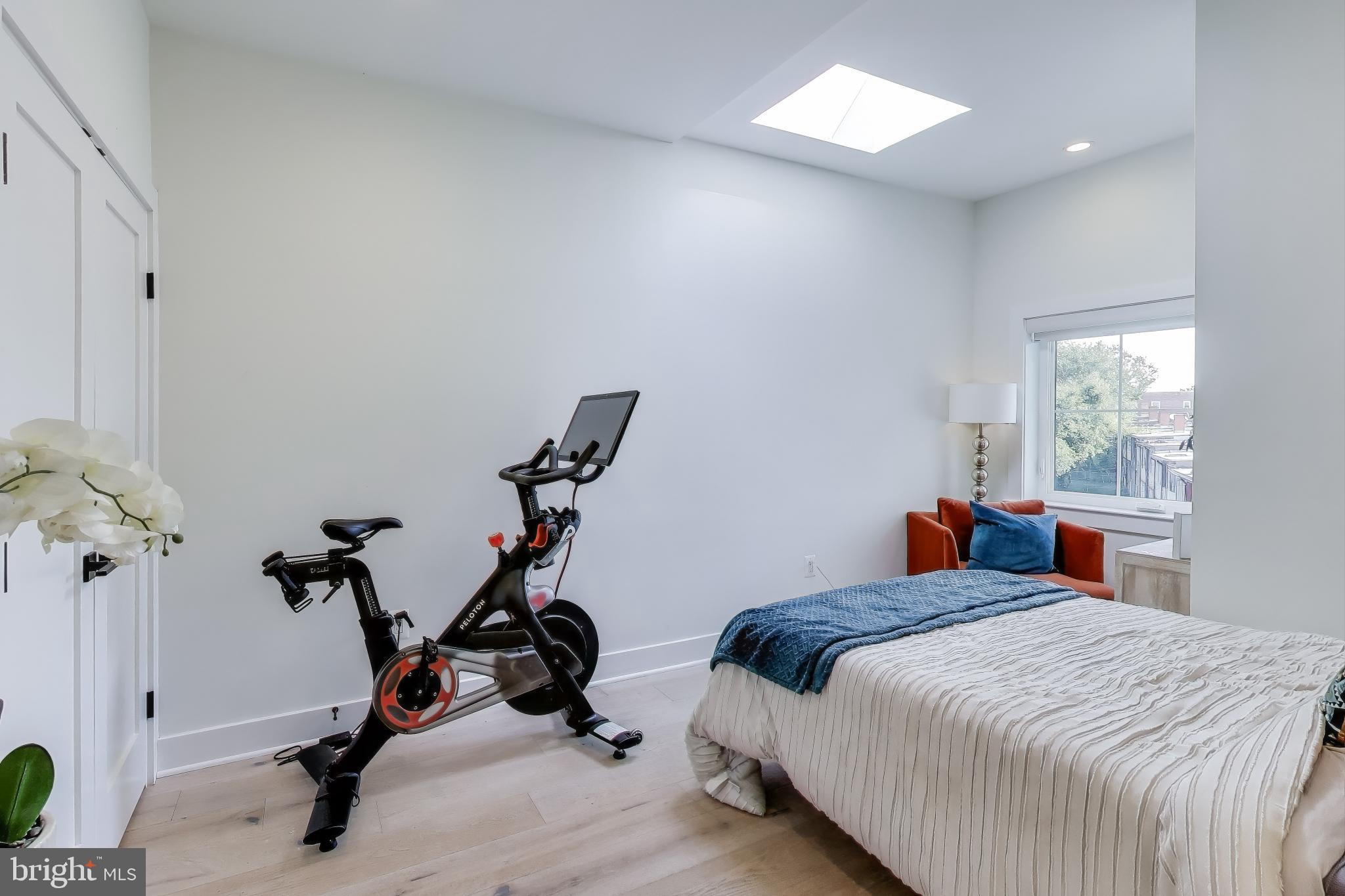 1011 18th Street Northeast, Unit 8 Washington, DC 20002 - Photo 10 of 25 a bedroom with bed a window and gym cycle