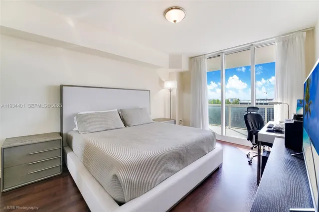 a bedroom with a bed and large windows