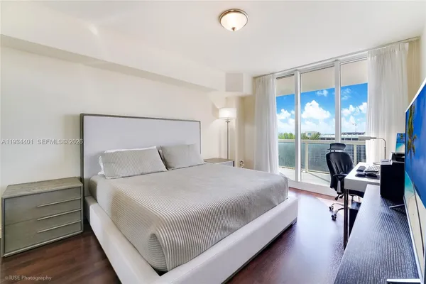 a bedroom with a bed and large windows