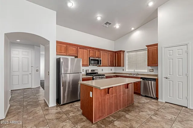 a kitchen with stainless steel appliances granite countertop a refrigerator a stove a sink and a refrigerator