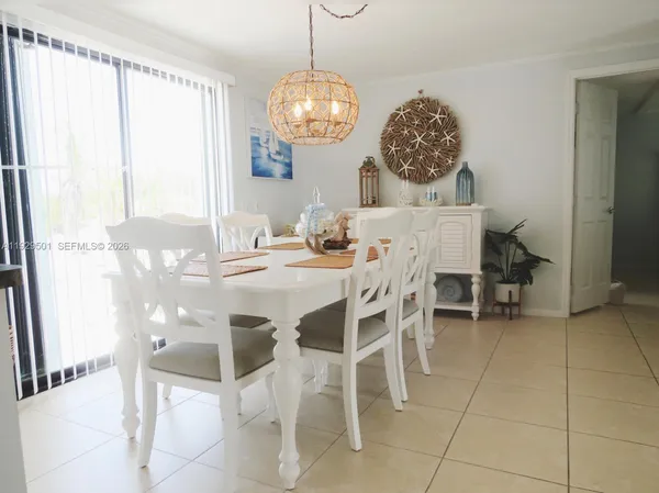 a view of a dining room with furniture and chandelier