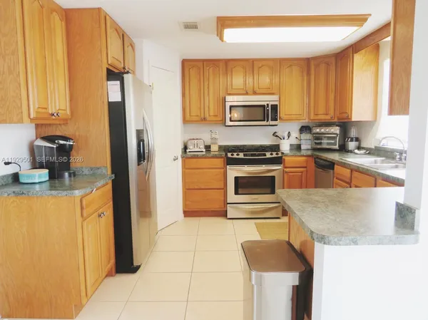 a kitchen with stainless steel appliances granite countertop a refrigerator a stove top oven a sink and dishwasher