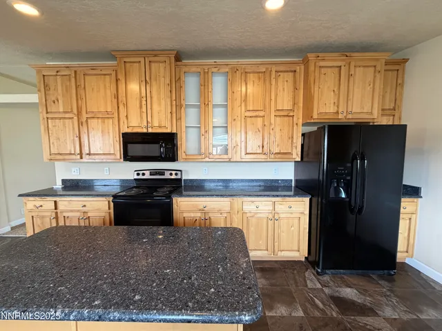 a kitchen with stainless steel appliances granite countertop a refrigerator and a stove top oven