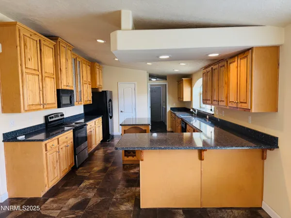 a kitchen with stainless steel appliances granite countertop sink stove and refrigerator