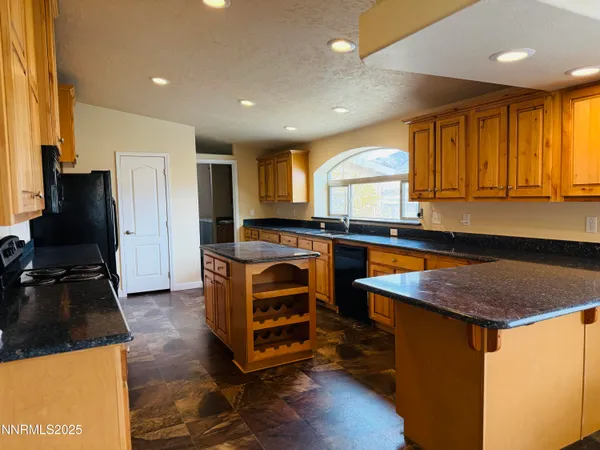 a kitchen with stainless steel appliances granite countertop a sink and a stove