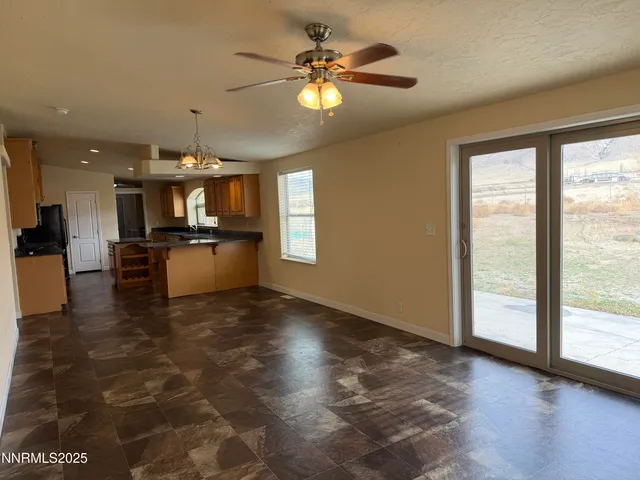 a view of a kitchen with kitchen island wooden floor appliances and a chandelier