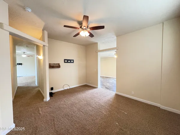 an empty room with closet and a chandelier fan