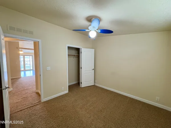 a view of an empty room with wooden floor and windows