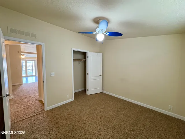 a view of an empty room with wooden floor and windows