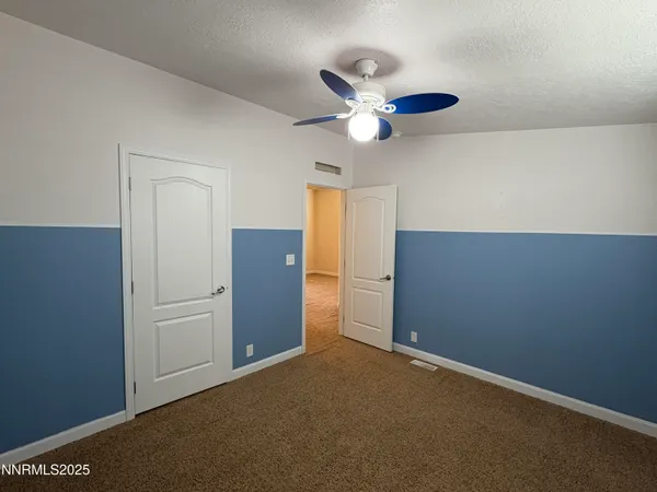 a view of a livingroom with a ceiling fan and entryway
