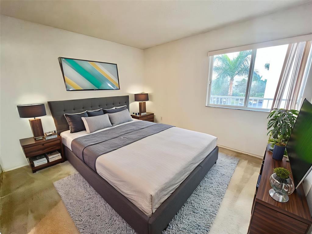 7763 Southampton Terrace, Unit 411 Tamarac, FL 33321 - Photo 13 of 33 a bedroom with a bed and a painting on the wall
