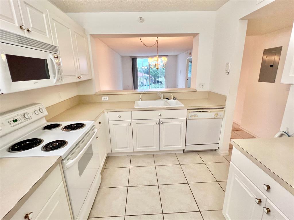 7763 Southampton Terrace, Unit 411 Tamarac, FL 33321 - Photo 2 of 33 a kitchen with a stove a sink and a microwave