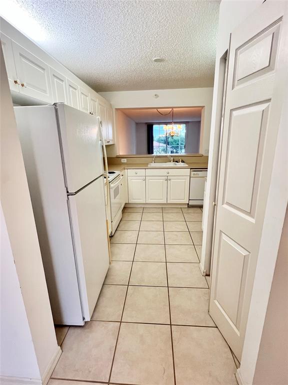 7763 Southampton Terrace, Unit 411 Tamarac, FL 33321 - Photo 4 of 33 a kitchen with a refrigerator a washer and dryer