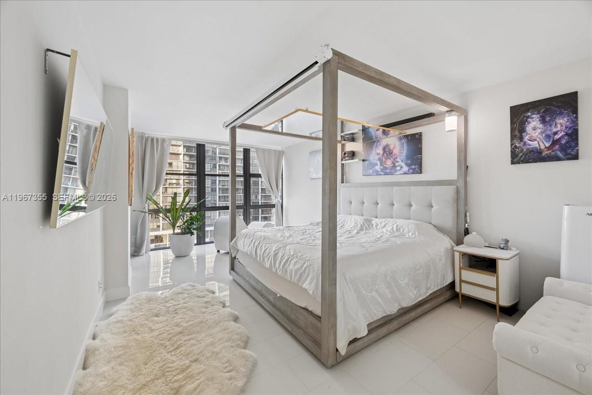 1915 Brickell Avenue, Unit 801 Miami, FL 33129 - Photo 17 of 37 a spacious bedroom with a bed and a large mirror