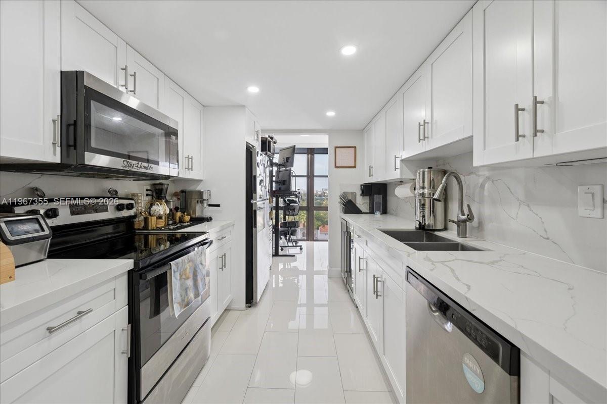 1915 Brickell Avenue, Unit 801 Miami, FL 33129 - Photo 10 of 37 a large kitchen with stainless steel appliances granite countertop a stove top oven a sink dishwasher and a microwave oven with large cabinets