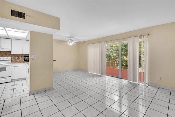 a view of empty room with wooden floor and window