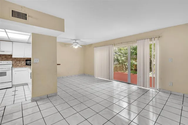 a view of empty room with wooden floor and window