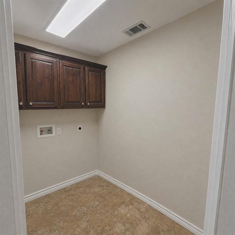 14752 Ranch Road Forney, TX 75126 - Photo 13 of 40 Utility space featuring rich wood-finish cabinetry, ceramic tile flooring, and a flush-mount overhead light-This photo was taken before family moved in