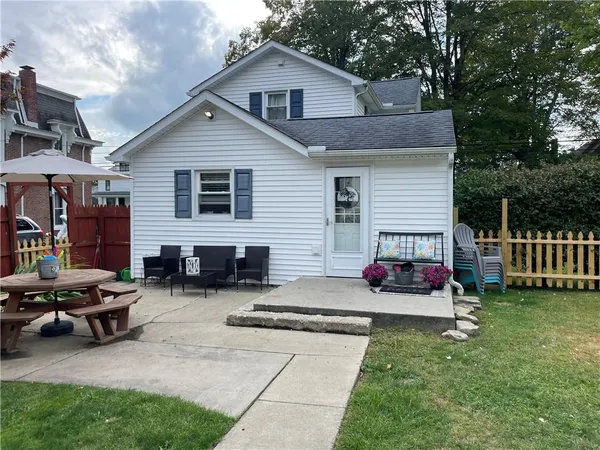 a view of a chairs and table in backyard of the house