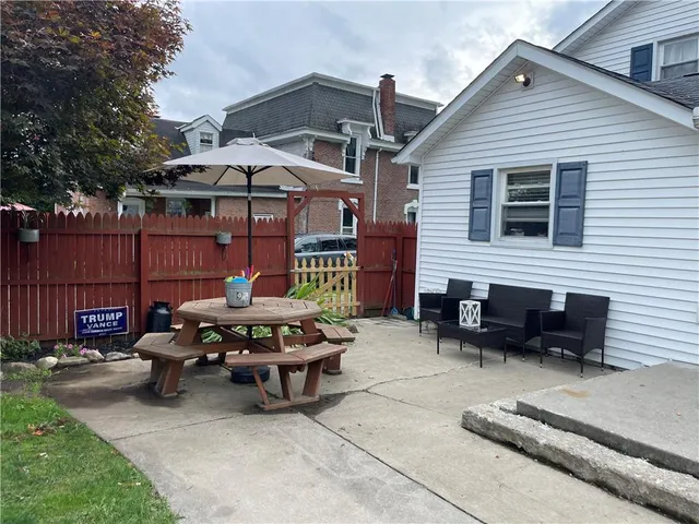 a backyard of a house with table and chairs