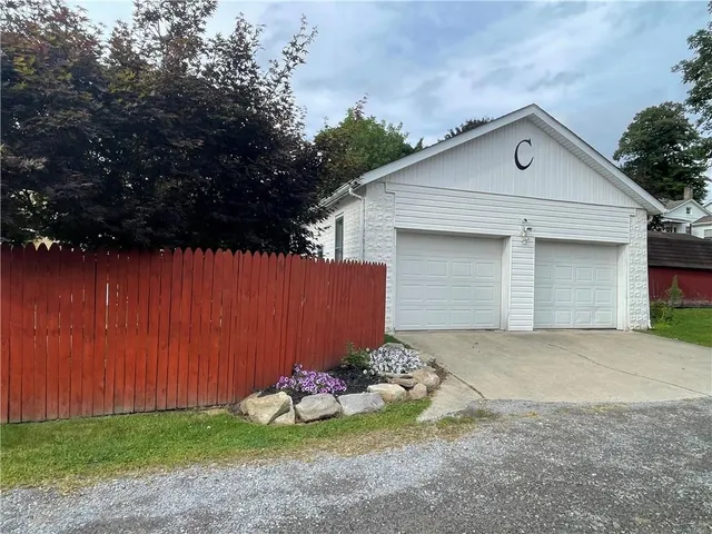 a view of a house with a yard and potted plants