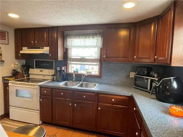 a kitchen with granite countertop wooden cabinets and sink
