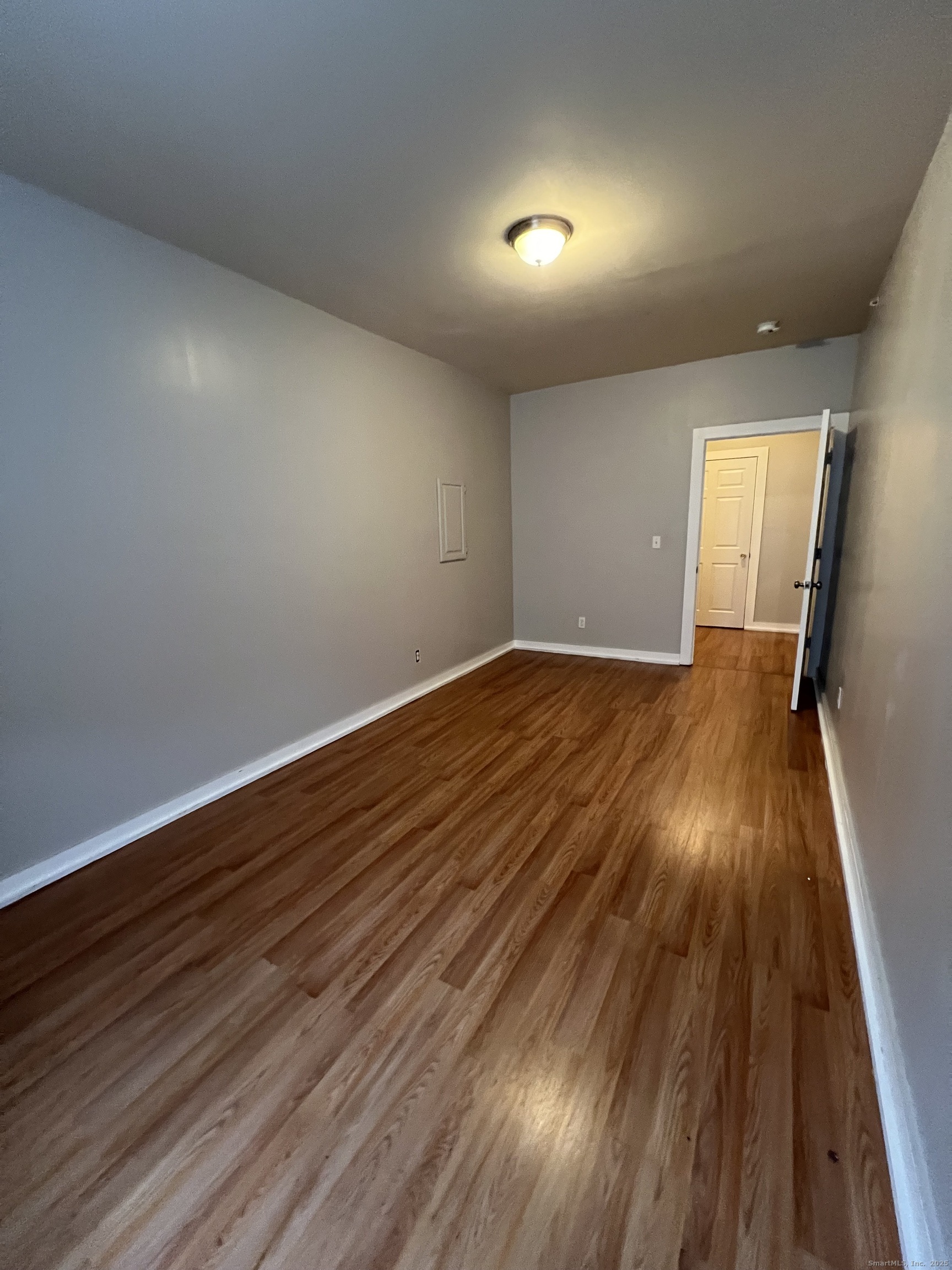 385 Putnam Avenue, Unit 18 Hamden, CT 06517 - Photo 14 of 14 an empty room with wooden floor and windows