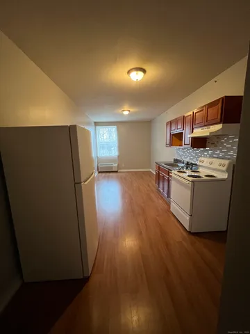 a kitchen with stainless steel appliances a refrigerator a stove a microwave and wooden floor