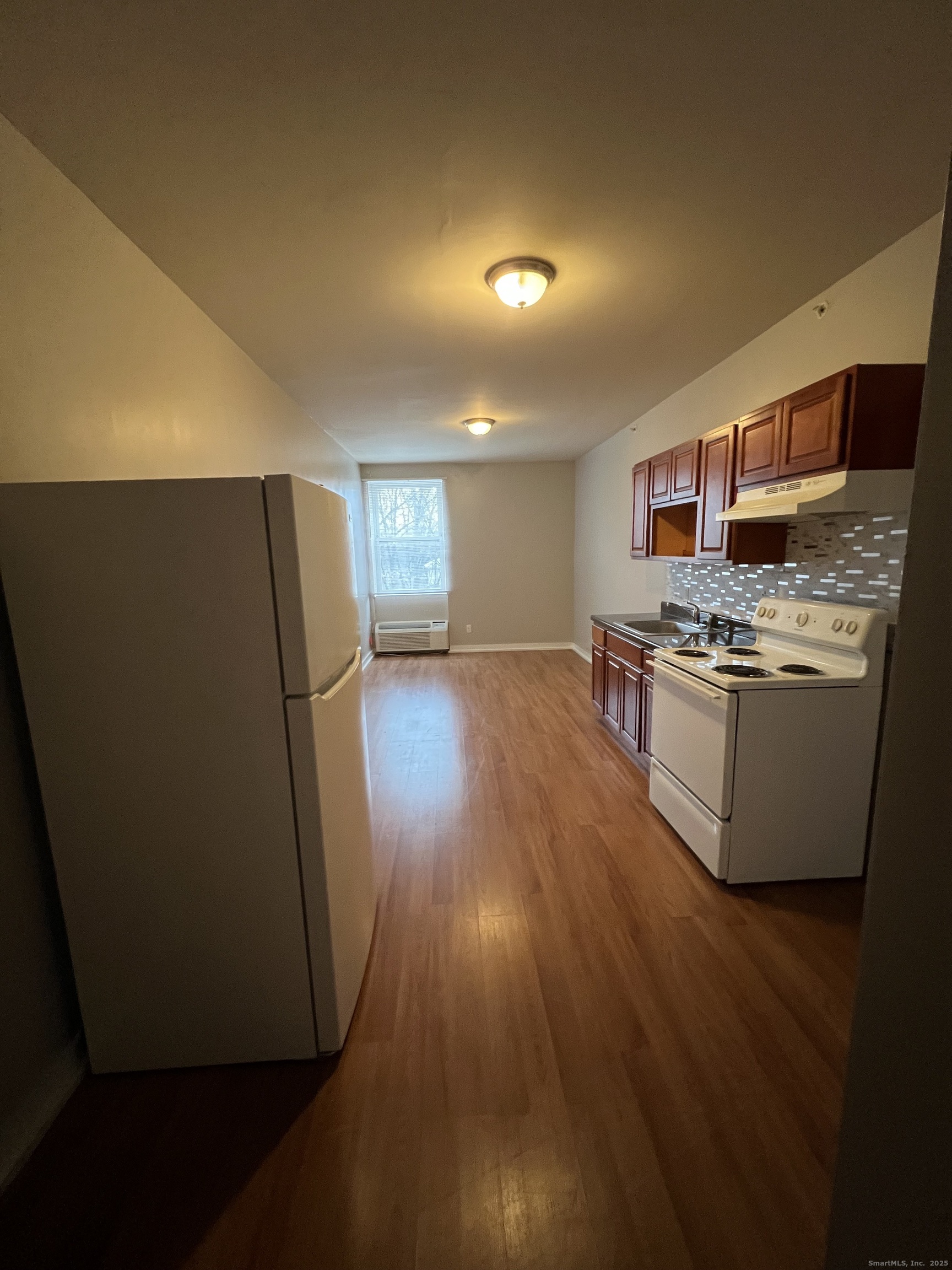 385 Putnam Avenue, Unit 18 Hamden, CT 06517 - Photo 2 of 14 a kitchen with stainless steel appliances a refrigerator a stove a microwave and wooden floor