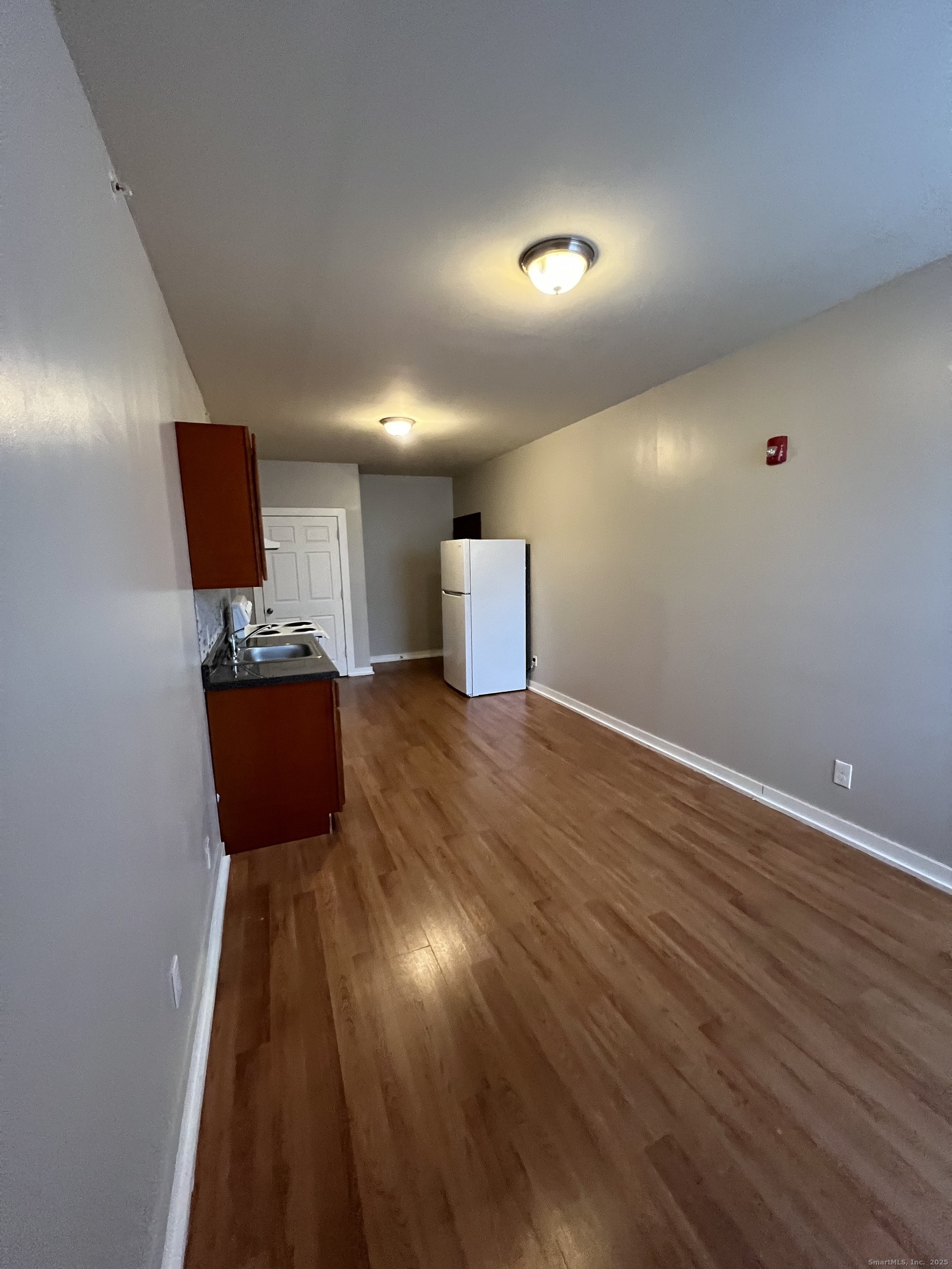 385 Putnam Avenue, Unit 18 Hamden, CT 06517 - Photo 3 of 14 an empty room with wooden floor and glass door