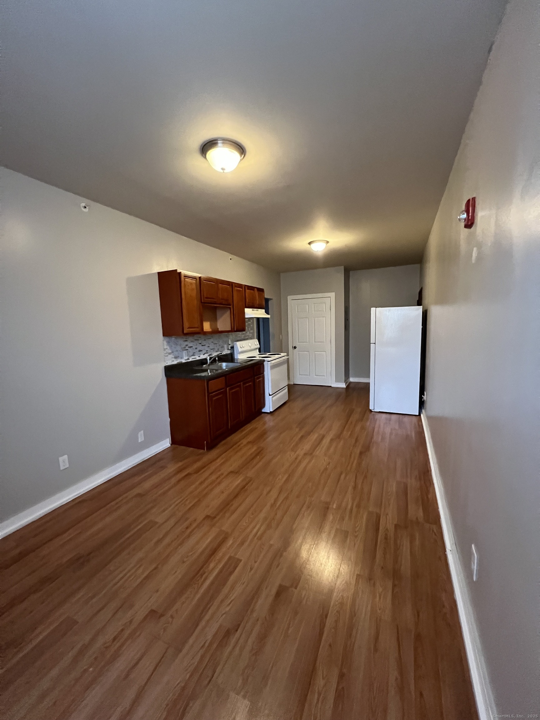 385 Putnam Avenue, Unit 18 Hamden, CT 06517 - Photo 4 of 14 an empty room with wooden floor and windows