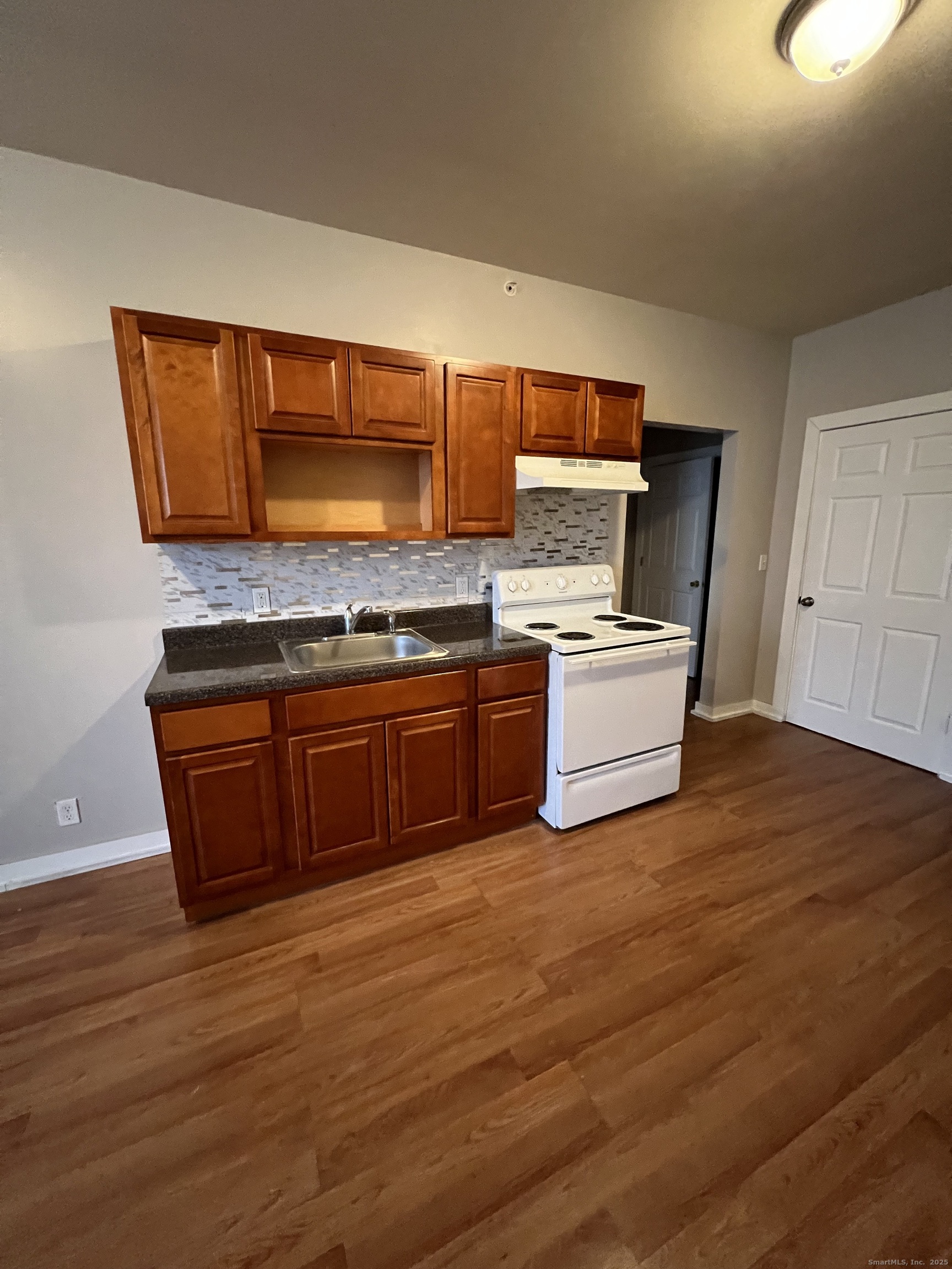 385 Putnam Avenue, Unit 18 Hamden, CT 06517 - Photo 5 of 14 a kitchen with a stove and wooden floor
