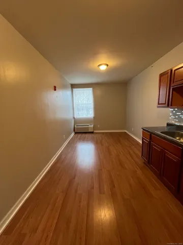 a view of a room with wooden floor and window
