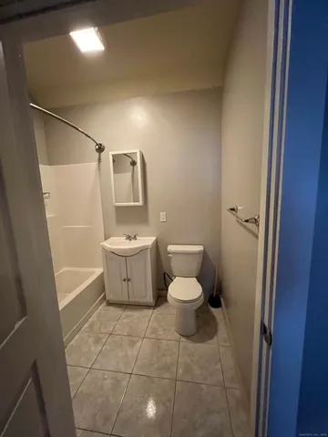 a white toilet sitting next to a bathroom sink and a mirror