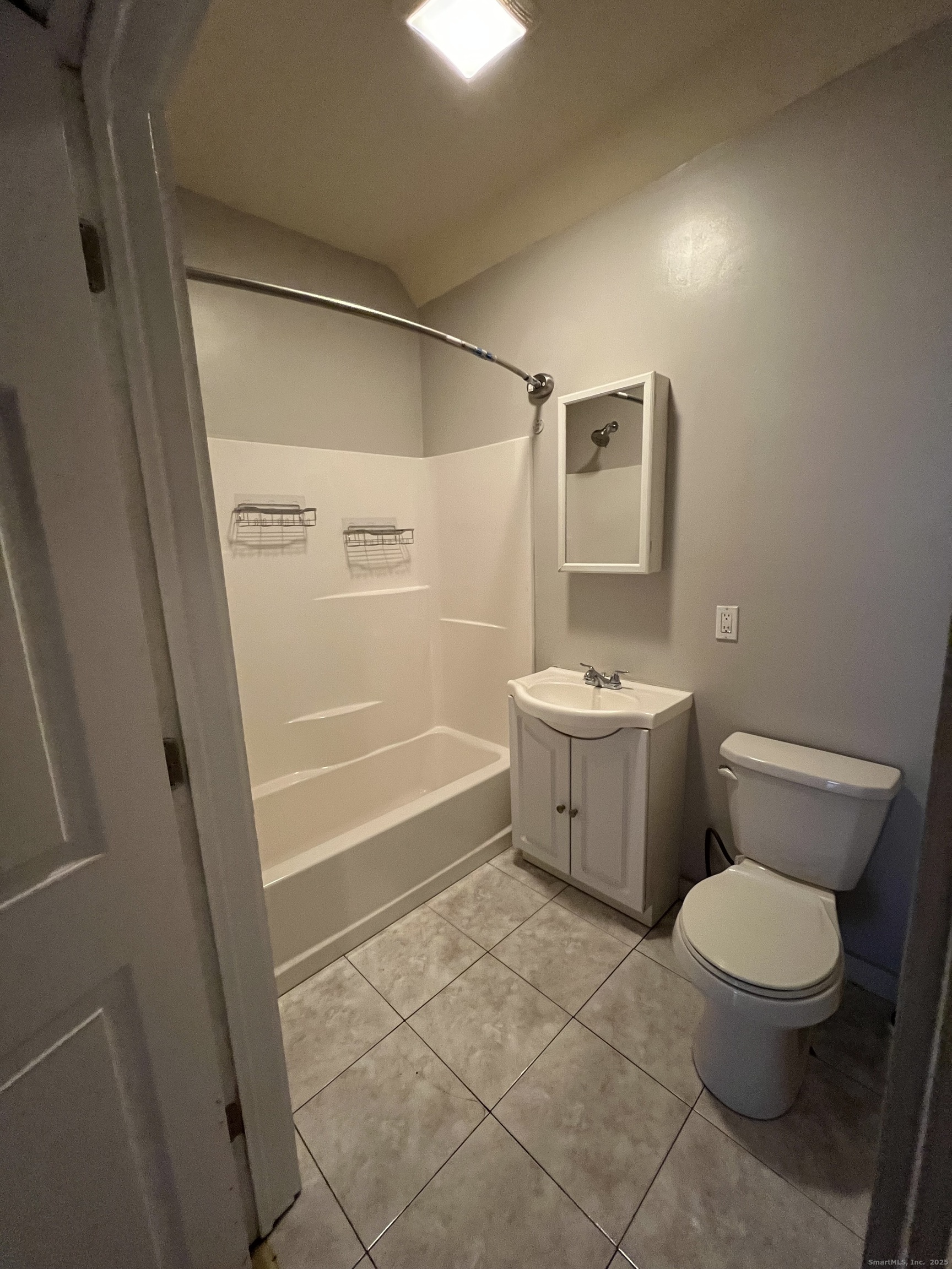 385 Putnam Avenue, Unit 18 Hamden, CT 06517 - Photo 8 of 14 a white toilet sitting next to a bathroom sink and tub