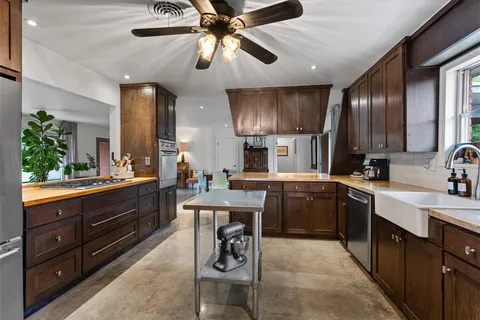 a kitchen with a sink a counter space appliances and cabinets