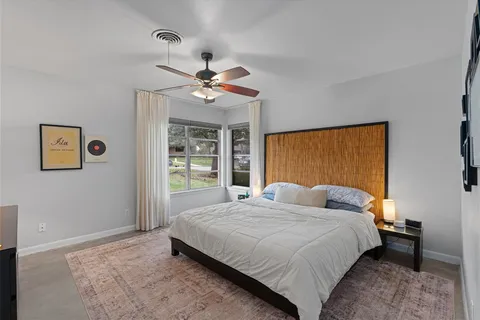 a bedroom with a bed ceiling fan and a window