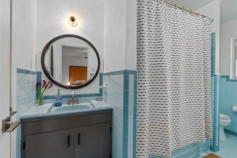 a bathroom with a sink a toilet and a mirror