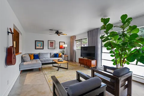 a living room with furniture plant and a large window