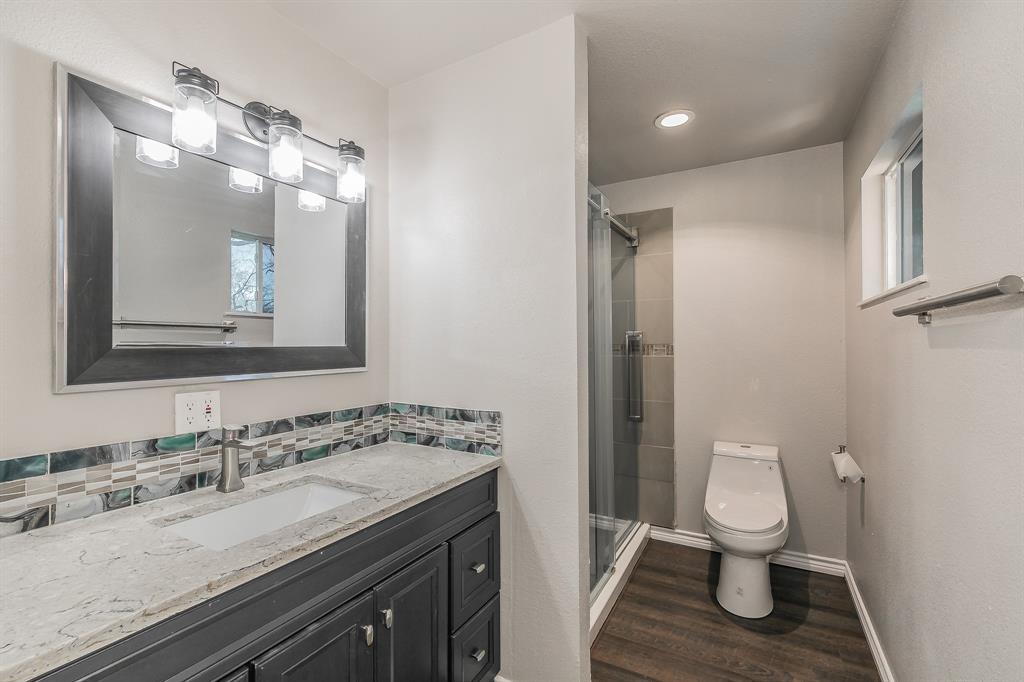 7612 Sommerville Place Road Fort Worth, TX 76135 - Photo 20 of 37 a bathroom with a granite countertop toilet a sink and a mirror