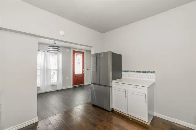 a kitchen with a refrigerator sink and white cabinets