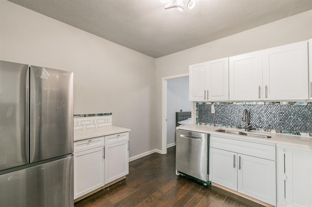 7612 Sommerville Place Road Fort Worth, TX 76135 - Photo 31 of 37 a kitchen with a refrigerator sink and white cabinets