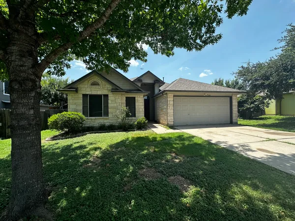 a front view of a house with a garden and yard