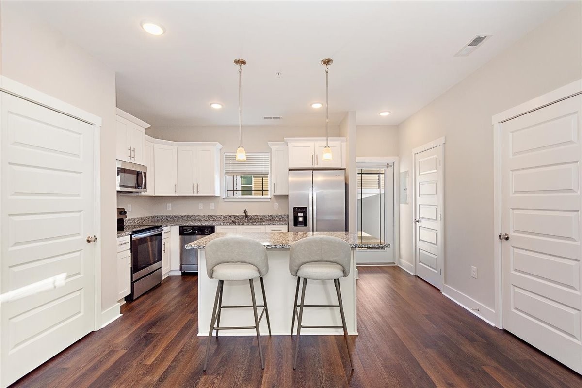 7000 Magnolia Crossings Spring Hill, TN 37174 - Photo 7 of 32 a kitchen with stainless steel appliances a refrigerator a stove top oven and white kitchen island