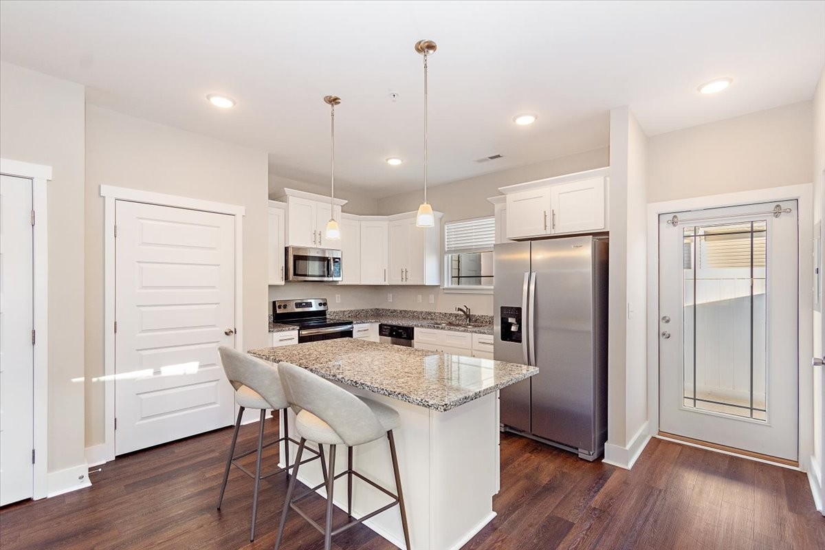 7000 Magnolia Crossings Spring Hill, TN 37174 - Photo 8 of 32 a kitchen with stainless steel appliances a refrigerator a sink dishwasher a stove and white cabinets with wooden floor